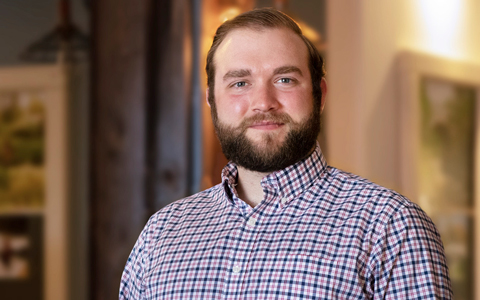 Ben Galligan smiling in a plaid shirt.