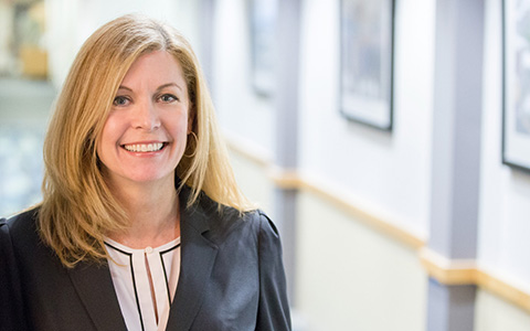 Elizabeth Bennett wearing a dark suit jacket pictured in an office setting.