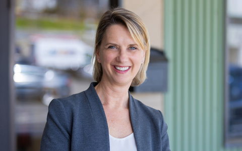 Meredith Avery smiling in a Dark gray blazer.