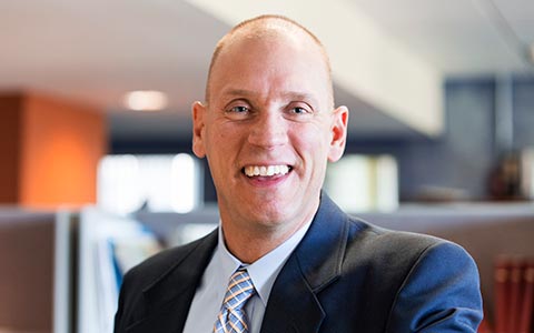 Rob Smedberg smiling, wearing a navy blazer.