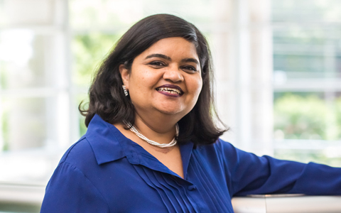 Taruna smiling in a navy blue blouse.