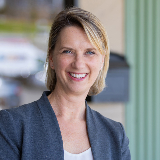 Meredith Avery smiling in a Dark gray blazer.