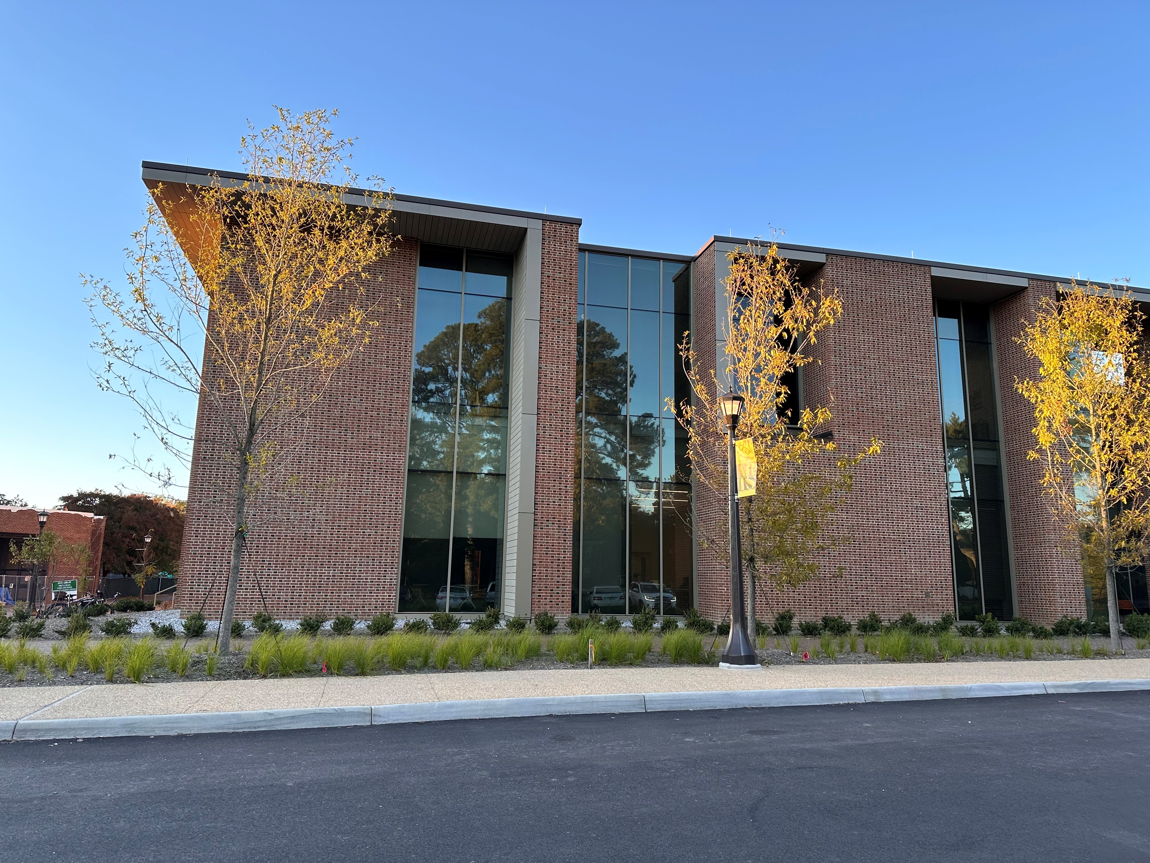 Exterior of a new brick building with floor to ceiling windows.