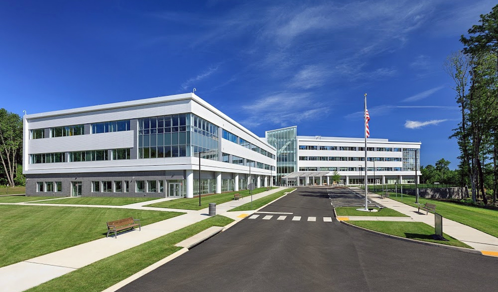 Circulation at the front entrance of the Sheltering Arms Hospital that includes sidewalks, a pedestrian crosswalk, and vehicle drop off.