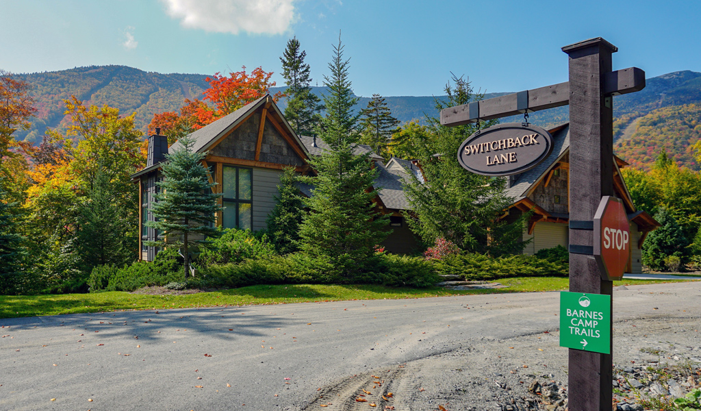 View of the winding road leading to Switchback Terrace Drive and new homes set within the mountains in fall. 