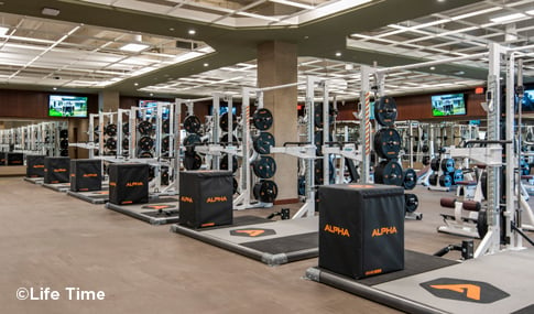 Rows of weight machines inside Life Time Fitness Framingham.