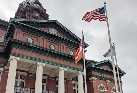 An historic brick two story building with flags in front