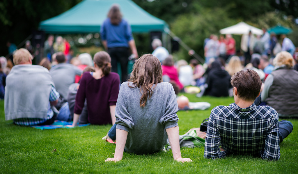 Community gathered in green space and enjoying an outdoor event.