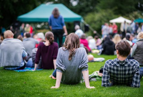 Community gathered in green space and enjoying an outdoor event.