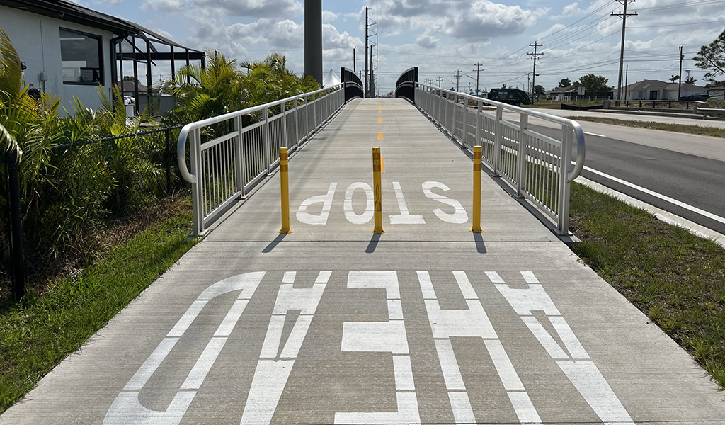 Painted letters indicating Stop Ahead on a multimodal trail path.