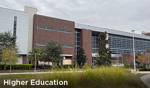 A classroom building with native grasses and trees planted in front