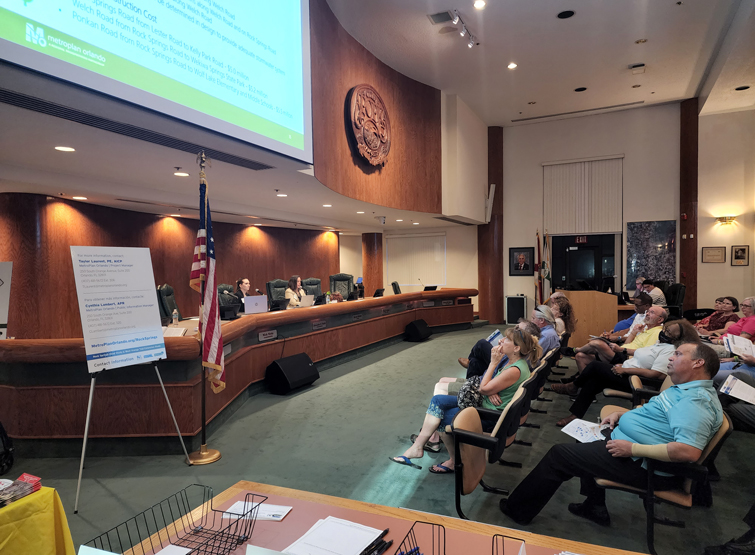 A group of people at a public meeting are discussing transportation alternatives