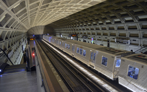 The existing Metrorail station train platform with a train stopped for riders.