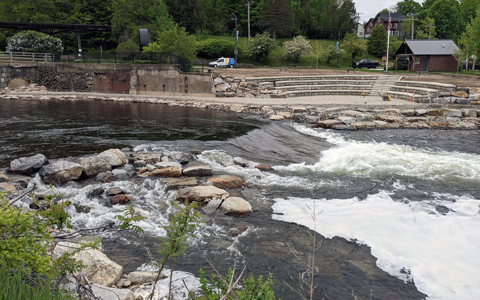 Whitewater rapids with rocks and seating area.