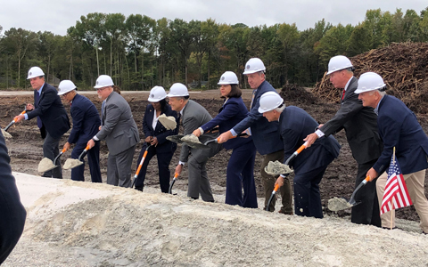 Project stakeholders hold shovels and move dirt to signify the groundbreaking of the new CBOC Hampton Roads.