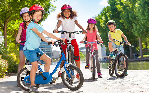 Children ride bikes in city park