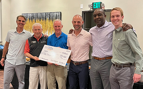 Sean Nicol, far right, presenting a check to local charity with other Tobacco Road Marathon members.