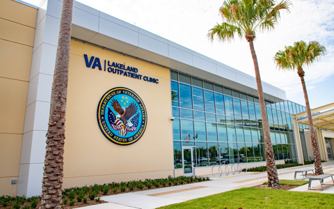 A healthcare building with tall palm trees.