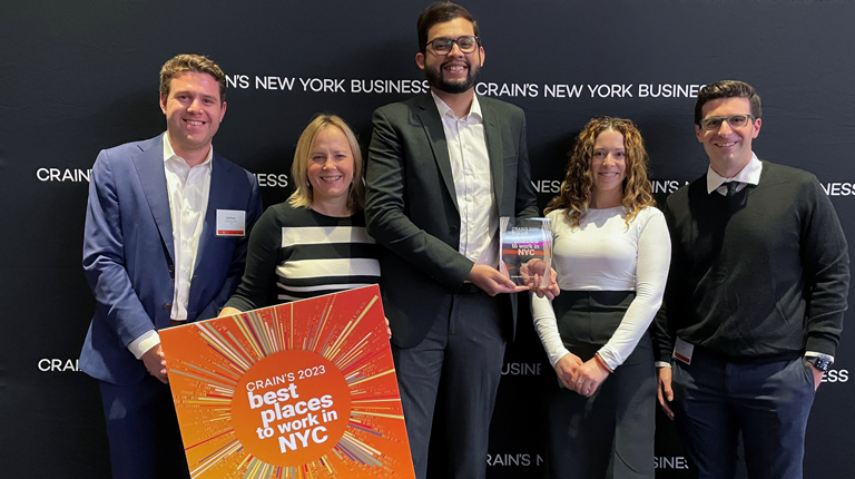 VHB team members posing with the Crain’s Best Places to Work award.