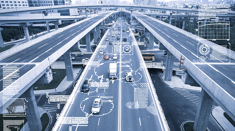 Cars drive along a five-lane highway. Computerized circles and lines appear around the cars to display a traffic management system. 