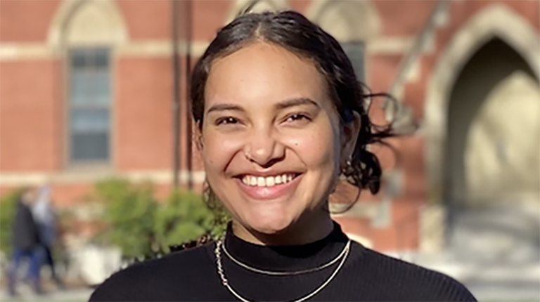 Isabella Buford smiling outside, dressed in a black shirt, highlighting her participation in Tufts REPP program.