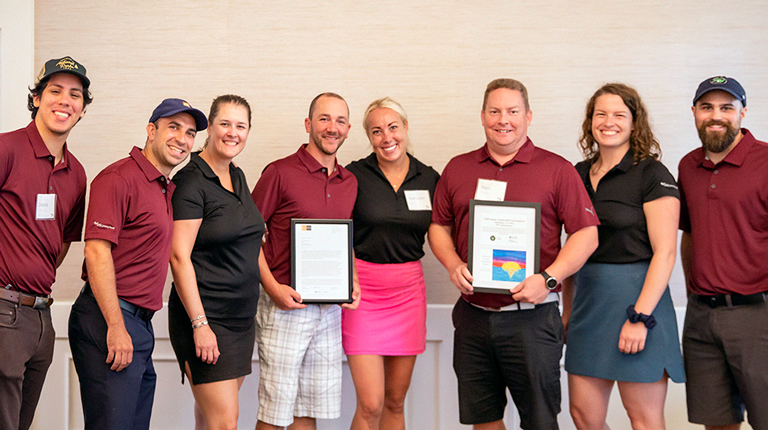 Eight smiling VHBers in golf attire.