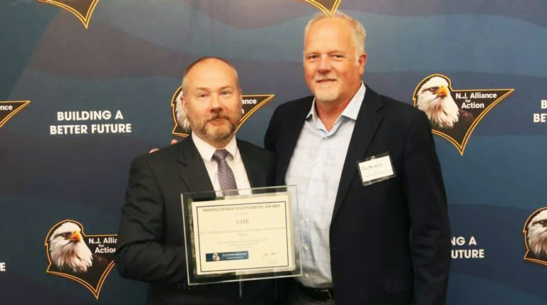 Two men holding an award.