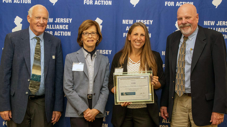 Four people smiling with an award.