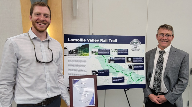 VHB team members smiling in front of project poster.