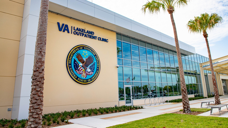 A healthcare building with tall palm trees.