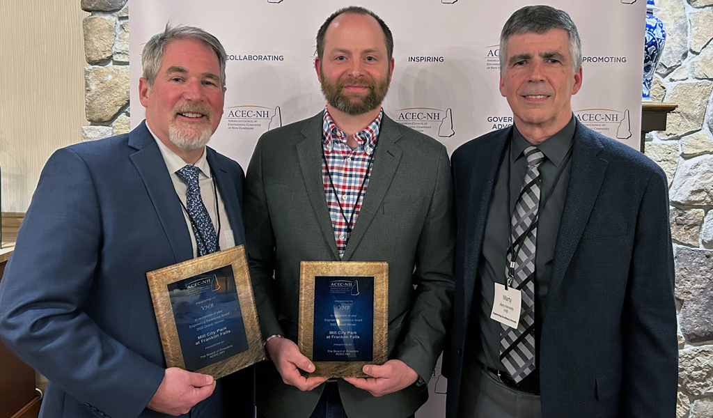 Three men posing with award plaques.