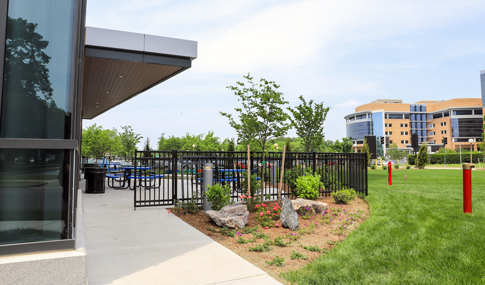 A gated outdoor seating area that includes tables at the CHKD Children’s Mental Health Hospital.