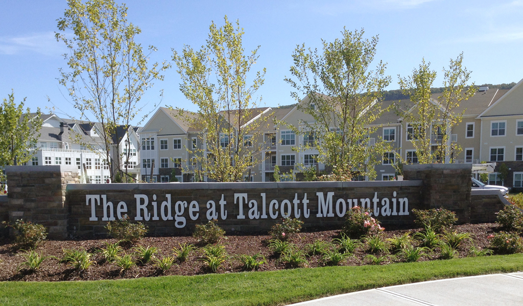 Stone sign at entrance to residential housing development.