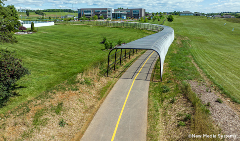 Protective fencing over a section of the trail to shield users from the adjacent Heritage Oaks golf course driving range. 