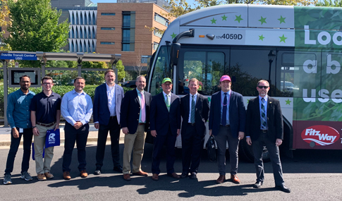 Nine project stakeholders smile together for a photograph.