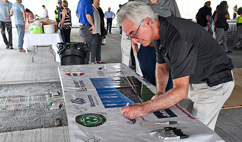 David Wilcock signs the project team banner.