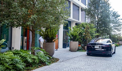 A car is parked in front of a valet area.