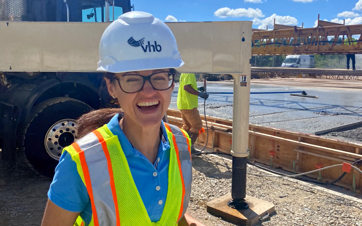 Olivia Richards in a VHB hard hat and safety vest, laughing at the camera