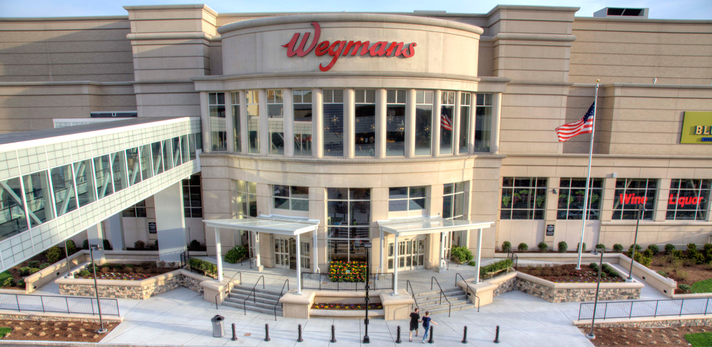 Exterior of a three-story Wegman's store in Massachusetts, including a pedestrian crossing