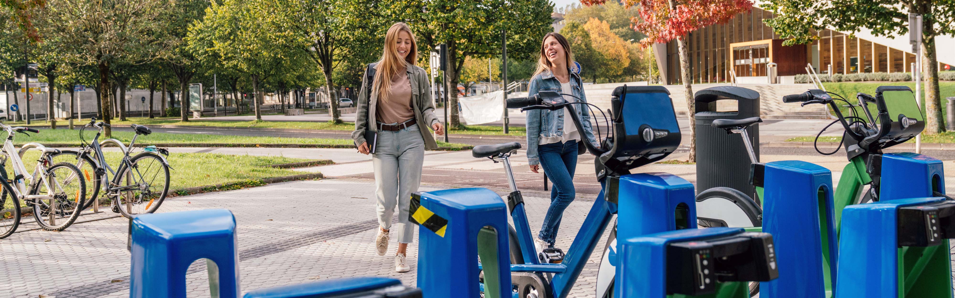 Two women standing next to a bicycle