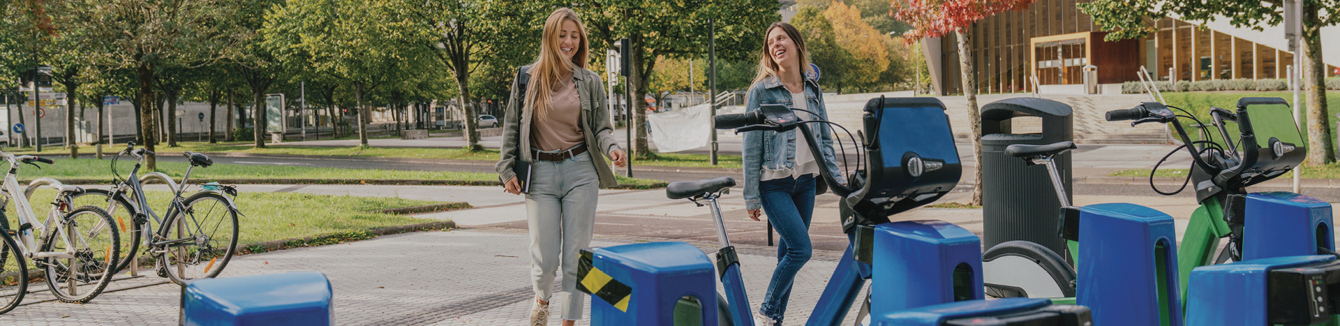 Two women standing next to a bicycle