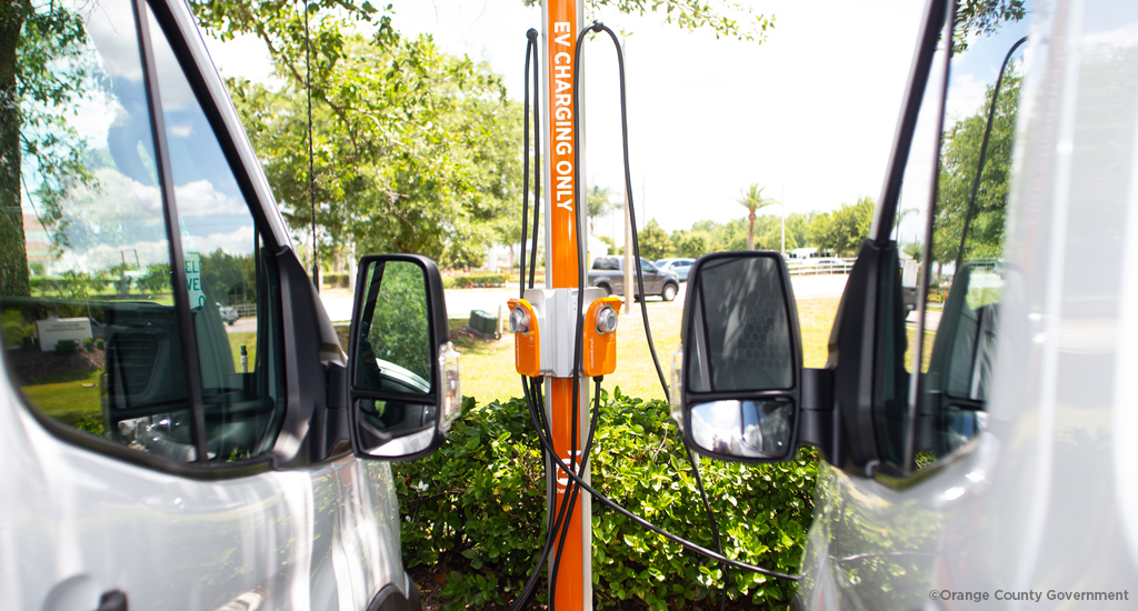 Two vehicles parked at an EV charging station. 