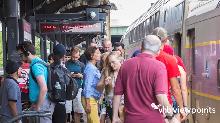 People board and deboard a train at a crowded station